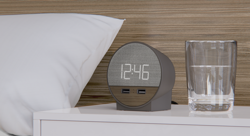 Charcoal color of Station O Alarm Clock with USB Ports sitting on bedside table.